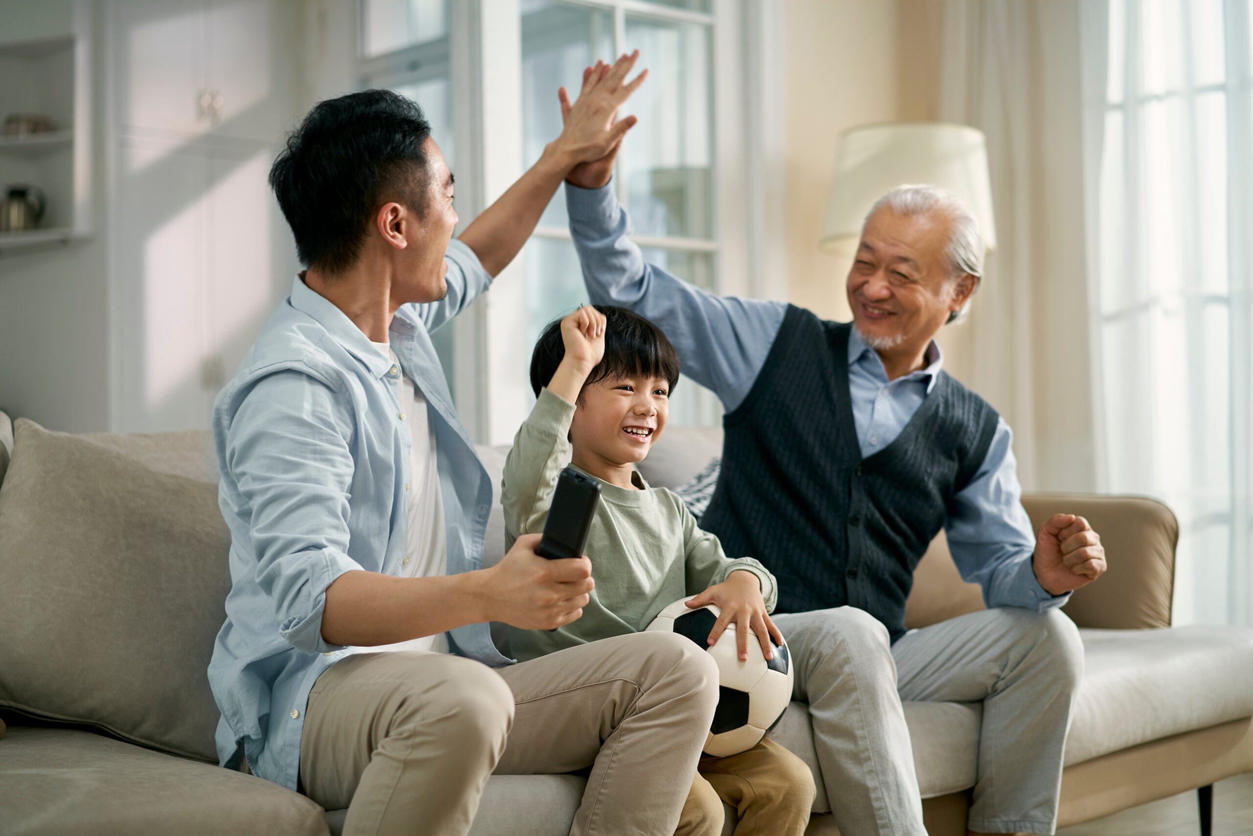 asian son father grandfather sitting on couch at home