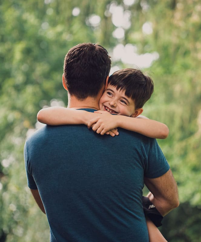 boy hugging and being held by his dad